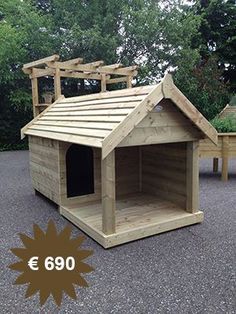 a wooden dog house sitting on top of a gravel road