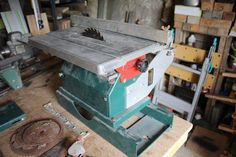 a machine that is sitting on top of a wooden table in a room filled with tools