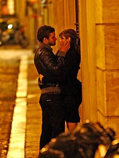 a man and woman kissing on the street