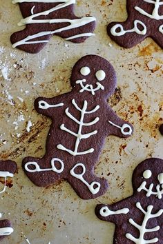 several decorated cookies with white icing on a baking sheet in the shape of skeletons