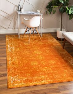 an orange rug in the corner of a room with a white chair and table next to it