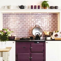 a purple stove top oven sitting inside of a kitchen