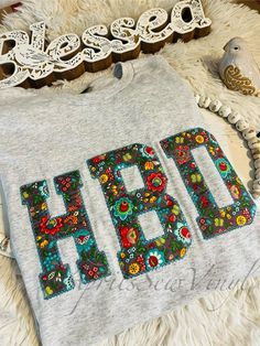 a t - shirt with the word hope written in floral letters on it next to a bird