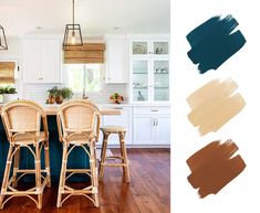 a kitchen with white cabinets and wooden floors, painted in shades of teal brown