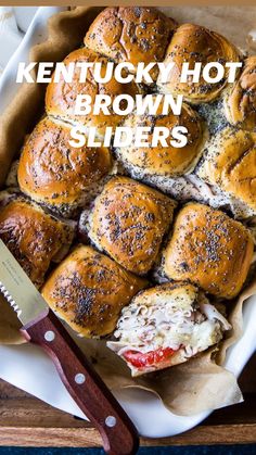 a platter filled with rolls covered in cheese and meats next to a knife