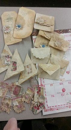 several pieces of paper with lace and bows on them are laid out on a table