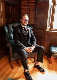 a man in a suit and tie sitting on a chair with his feet propped up