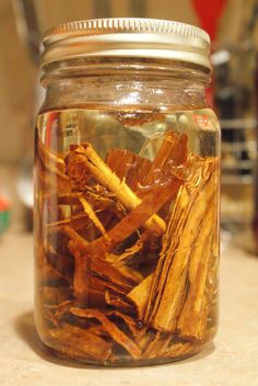 a glass jar filled with lots of different types of dried items on top of a counter