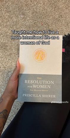 the resolution for women book being held up by a person's hand with tattoos on it