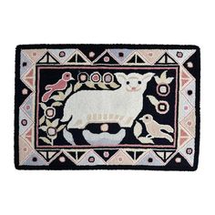 a rug with a sheep and flowers on the front is shown in black, pink, and white