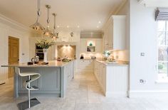 a large kitchen with white cabinets and counter tops