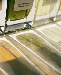 two bottles of cologne sitting on top of a table