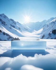 an ice block sitting in the snow with mountains in the background