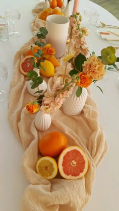 the table is set with oranges, lemons, and other fresh fruit on it