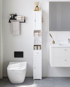 a white bathroom with a toilet, sink and mirror