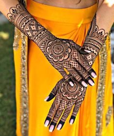 a woman with henna tattoos on her hands and arms, holding onto the wrist