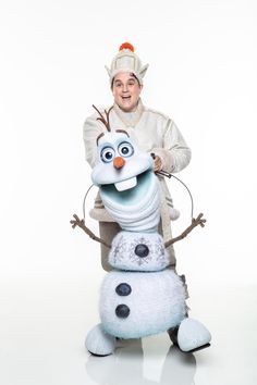 a man in costume is sitting on top of a snowman