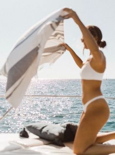 a woman sitting on the back of a boat holding an umbrella