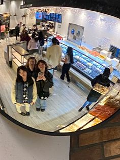 two women are taking a selfie in front of the food section of a store