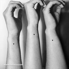 three arm tattoos with small hearts on them