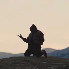 a person running up a hill with mountains in the background