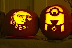 two carved pumpkins sitting on top of a table with an image of a man and woman