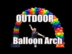 a man standing in front of an arch made out of balloons with the words outdoor balloon arch