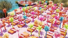 an aerial view of tables and benches with palm trees in the foreground, near water