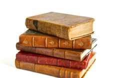 a stack of old books sitting on top of each other in front of a white background