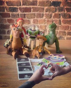 the toy story book is being held up by someone's hand while other toys sit around