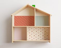 a wooden doll house with different patterns on the walls