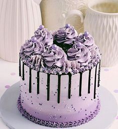 there is a cake with purple frosting on the table