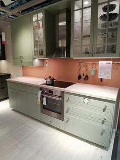 a kitchen with green cabinets and white counter tops