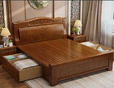 a wooden bed with drawers underneath it in a living room next to two lamps and a window