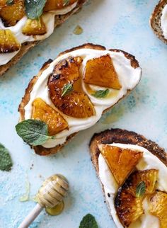 toasted bread topped with sliced oranges and whipped cream on a blue tablecloth