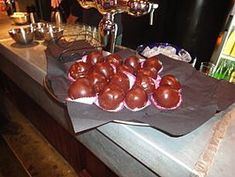 chocolate covered donuts are on a brown paper bag in front of a bar counter