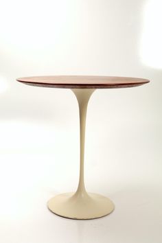 an oval wooden table sitting on top of a white floor