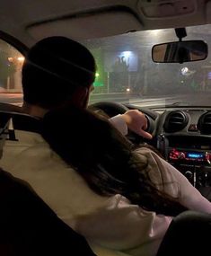 two people sitting in the driver's seat of a car