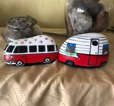 two painted rocks sitting on top of a bed