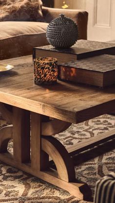 a wooden table sitting on top of a rug next to a couch