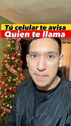 a man standing in front of a christmas tree with the caption'tu celular te avsia que quien te llama '