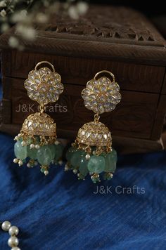 Discover the captivating charm of these mint kundan Jhumka earrings that gracefully illuminate any room you enter. The kundan-encrusted design exudes elegance and sophistication, reminiscent of an opulent era. The fluorite stones emit a radiant glow as you move, captivating all who see you. Closure - Push Back Weight - 87gms (Pair) Luxury Kundan Jhumkas With Zari Work, Luxury White Meenakari Danglers, Jhoomka Earrings, Chandbali Jhumkas For Celebrations, Fusion Kundan Jhumkas With Gota Work, Fusion Style Kundan Jhumkas With Gota Work, Green Jhumka, Luxury Fusion Style Jhumkas With Stone Work, Fusion Chandbali Jhumkas With Gota Work