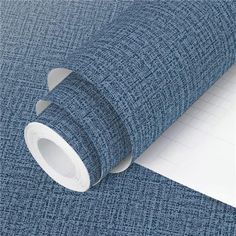 a roll of blue fabric next to a notepad