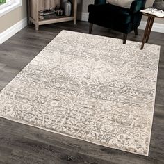 a large area rug with an ornate design on the floor in front of a chair