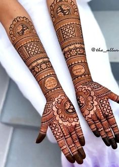 two hands with henna tattoos on them, one is showing off the intricate design