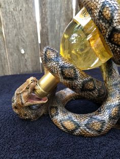 a snake drinking out of a bottle on top of a table