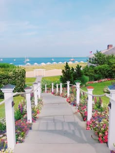 the walkway is lined with flowers and white pillars