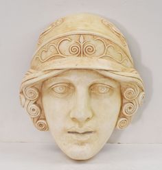 a sculpture of a woman's head wearing a hat with spirals on it