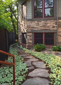 a brick house with stone walkway leading up to the front door and side yard area