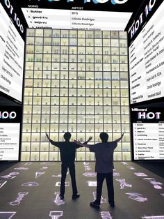 two people standing in front of a large display